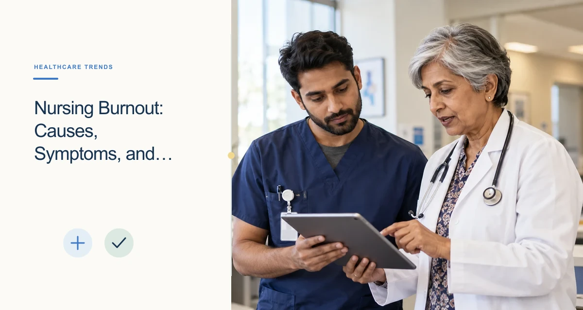 An older South Asian physician and a younger nurse review a tablet together at a clinic workstation.