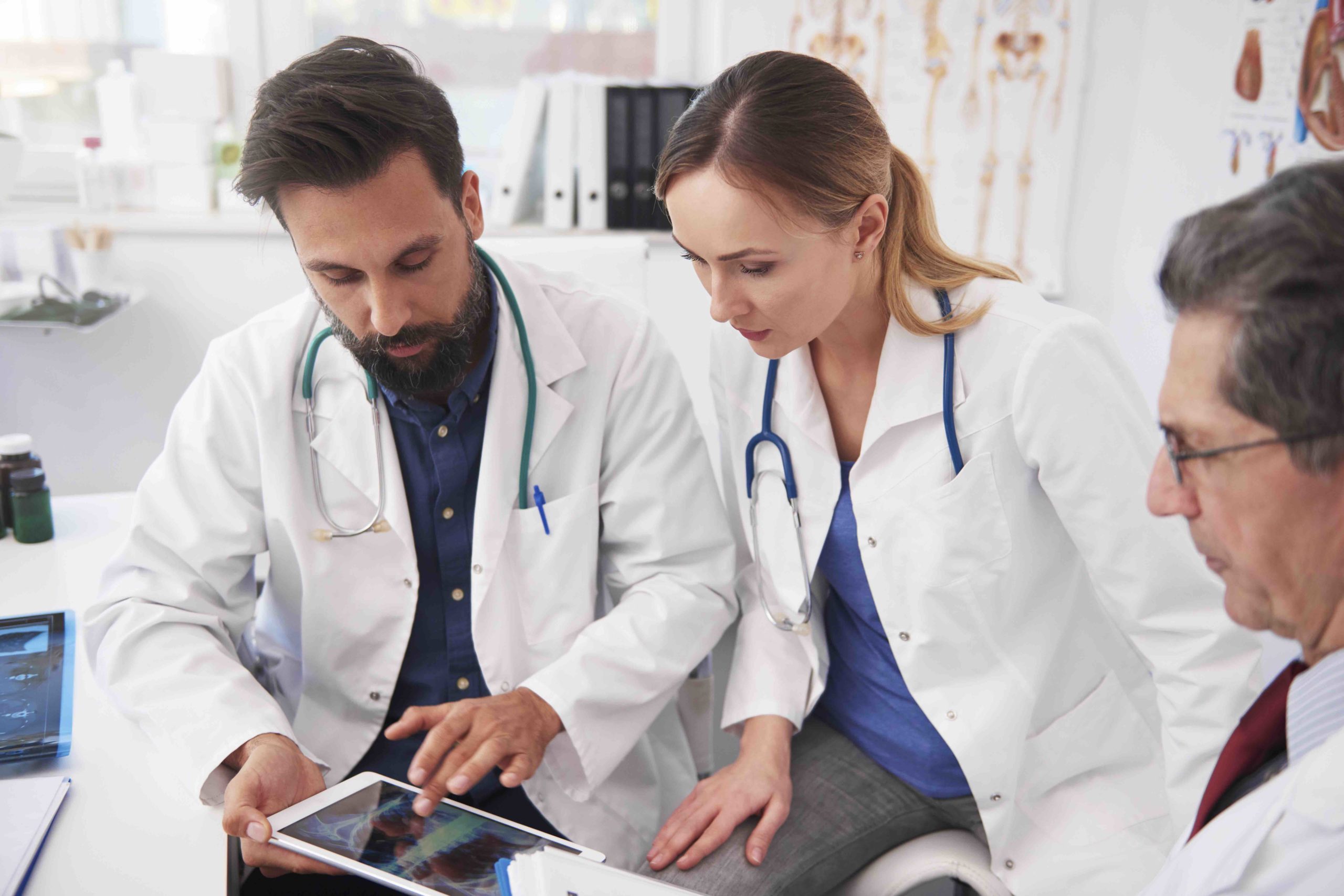 Three doctor working with tablet in doctor’s office doctors working with tablet
